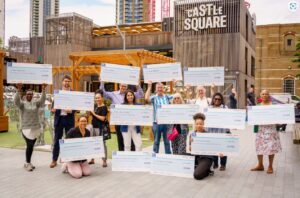 Community Groups holding giant cheques